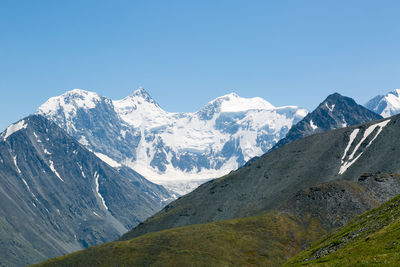 Scenic view of snowcapped mountains against clear blue sky