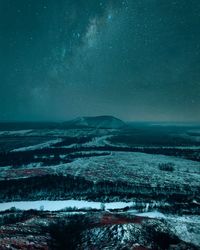 Scenic view of snowcapped mountains against sky at night