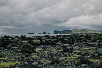 Scenic view of beach against cloudy sky