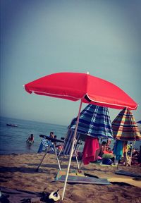 People on beach against clear sky