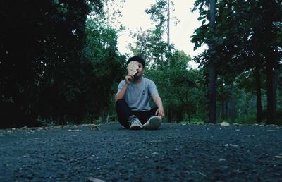 Portrait of young man sitting on land