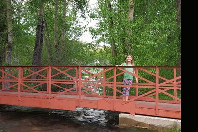 Man on bridge over river in forest