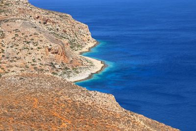 High angle view of sea shore against blue sky