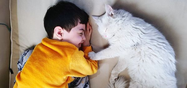 Cat and my son sleeping on bed at home