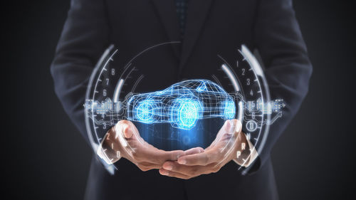 Midsection of man wearing mask against black background