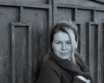 Portrait of woman leaning on wall