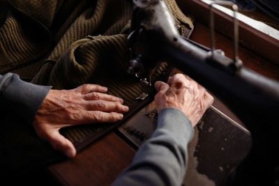 Cropped hands of tailor using sewing machine