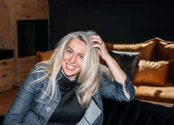 Contemplative mature woman lounging in a dark room with soft lighting