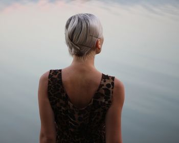 Rear view of woman standing against sky