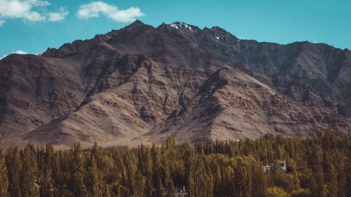 Scenic view of mountain range against cloudy sky