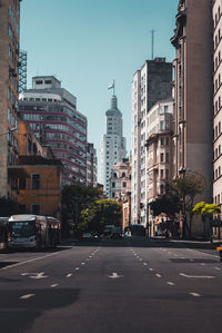 City street and buildings against clear sky