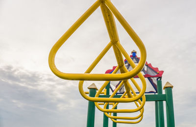 Close-up of yellow playground in park against sky