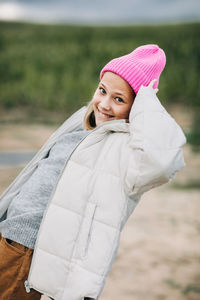 Portrait of smiling stylish teenage girl wearing pink fashion cap