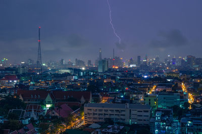 Illuminated cityscape against sky at night