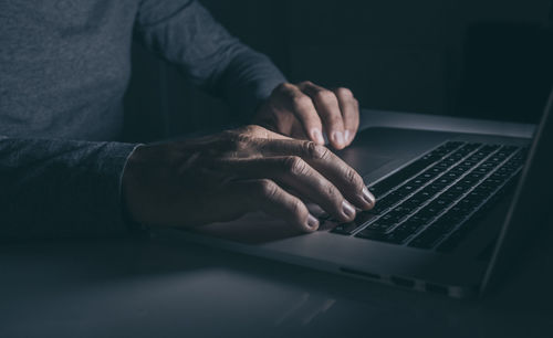 Midsection of man using laptop