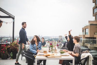 People sitting at restaurant table against clear sky