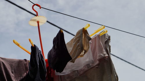 Low angle view of clothes drying on clothesline against sky