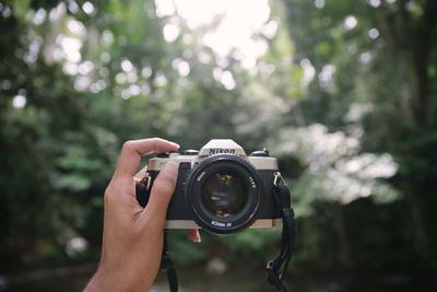 Midsection of person photographing camera
