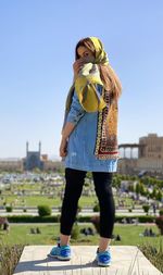 Full length of woman standing against naghshe jahan square esfahan iran