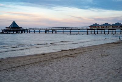 Pier over sea against sky during sunset