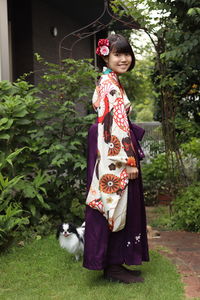 Full length of woman with dog standing against plants