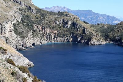 Scenic view of sea and mountains against sky