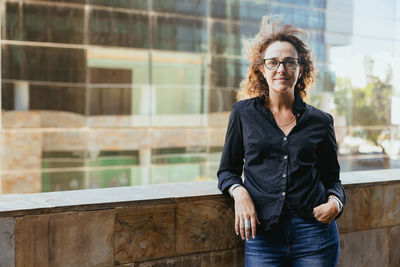 Portrait of young man wearing sunglasses while standing in city