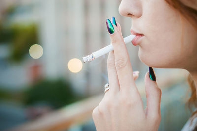 Close-up side view of woman smoking cigarette