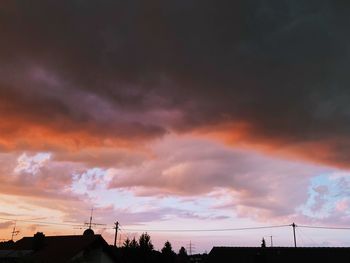 Low angle view of silhouette building against dramatic sky