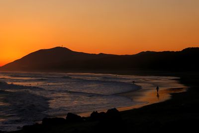 Scenic view of sea against orange sky