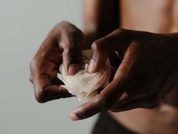 Midsection of man holding white rose