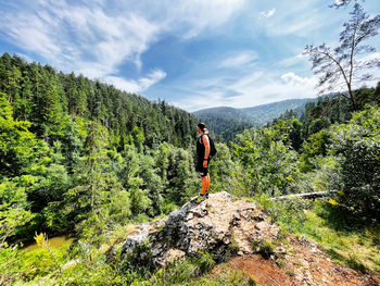 Rear view of woman walking on mountain against sky
