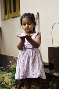 Portrait of baby girl standing against wall