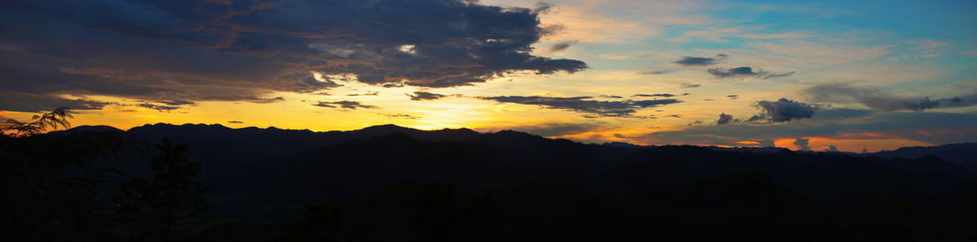 Low angle view of silhouette mountains against dramatic sky