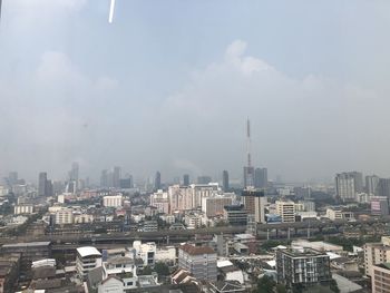 Aerial view of buildings in city against sky