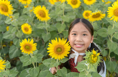 Portrait of smiling girl holding sunflower