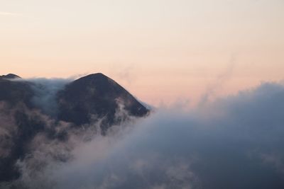 Idyllic shot of mountain in foggy weather against sky