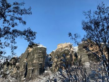 Low angle view of rocks against sky during winter