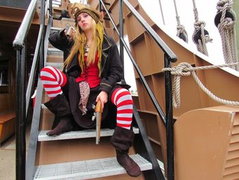 Young woman standing by railing