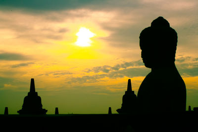 Silhouette statue against sky during sunset