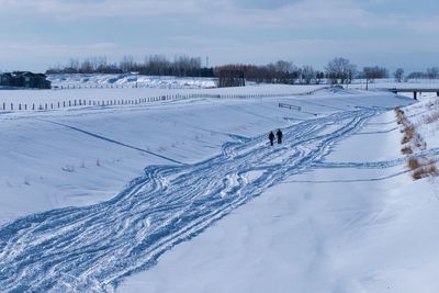 Scenic view of snow covered field against sky