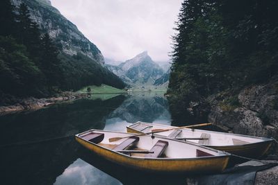 Scenic view of boats moored in lake against mountain range