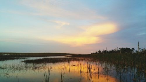 Reflection of clouds in lake at sunset