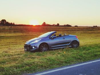 Car parked on field against clear sky