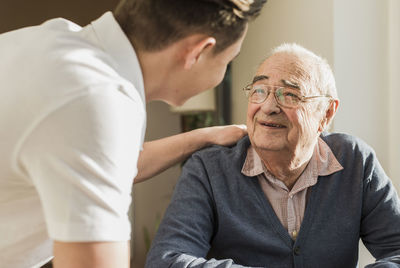 Portrait of smiling senior man face to face with his geriatric nurse