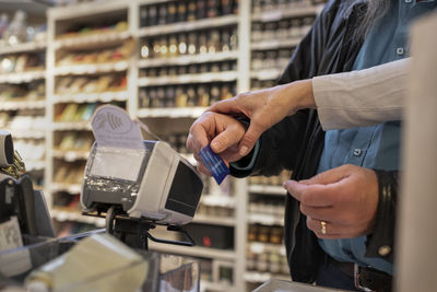 Close-up of hands using credit card reader