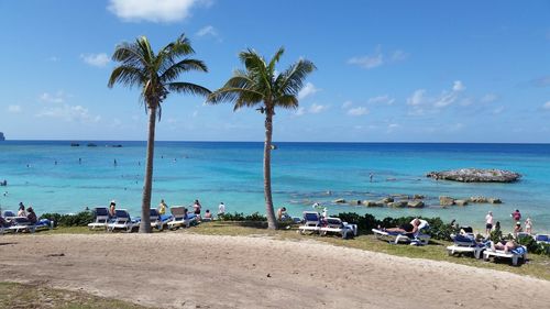 People on beach against blue sky