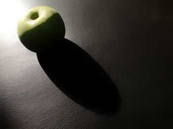 Close-up of apple on table against wall