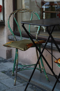 Close-up of empty chairs and table on footpath