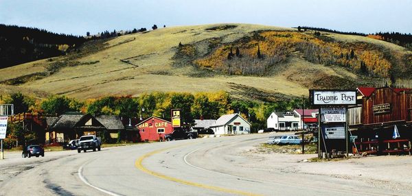 Road by buildings against sky in city